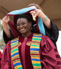 African American female doctoral graduate hooded at commencement