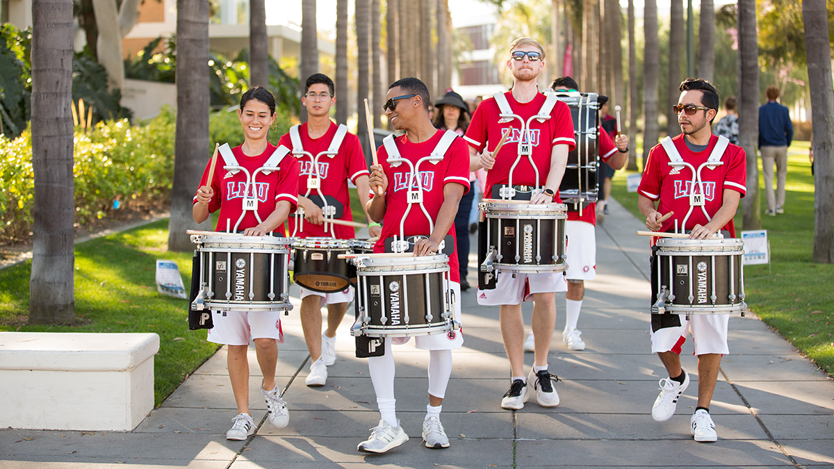students walking with their drum sets