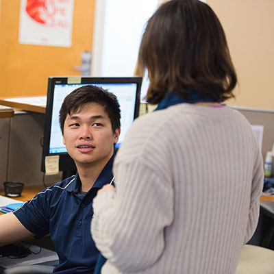 student worker talking to a staff member