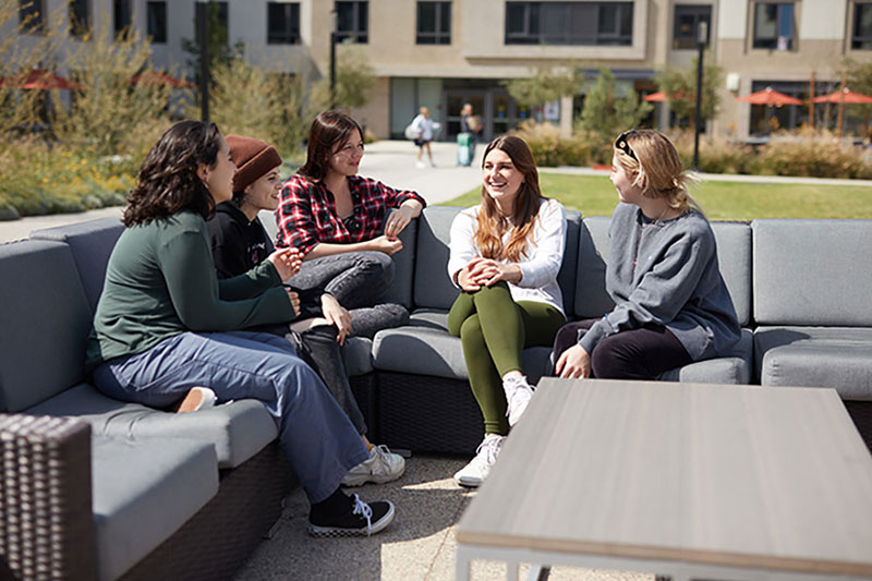 female students sitting on couches outside of Palm North