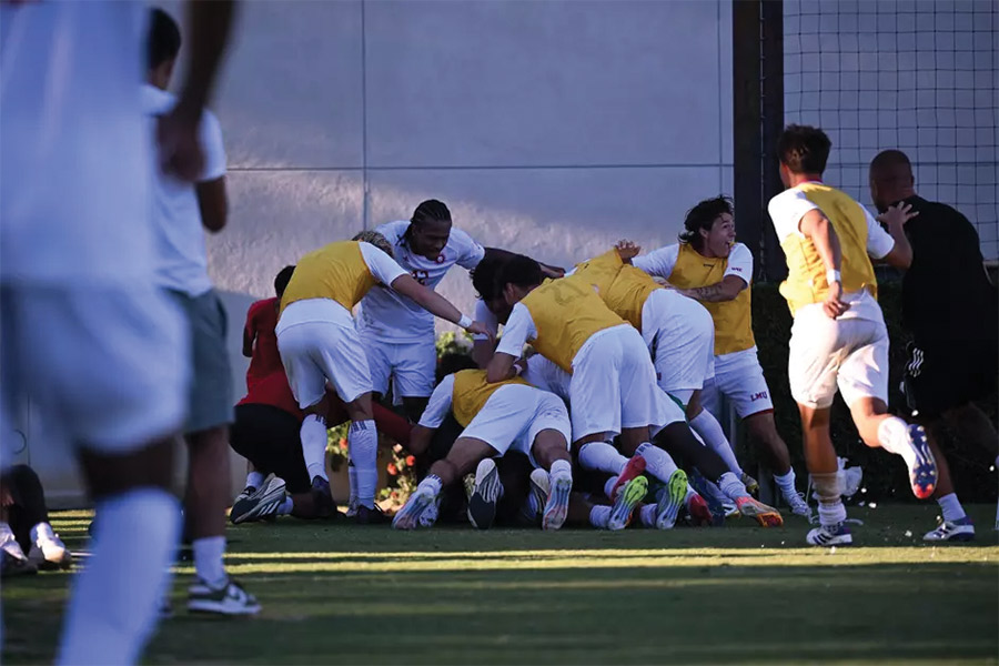 LMU Men's soccer team tackles Boyadjian after scoring a goal to beat the Bruins