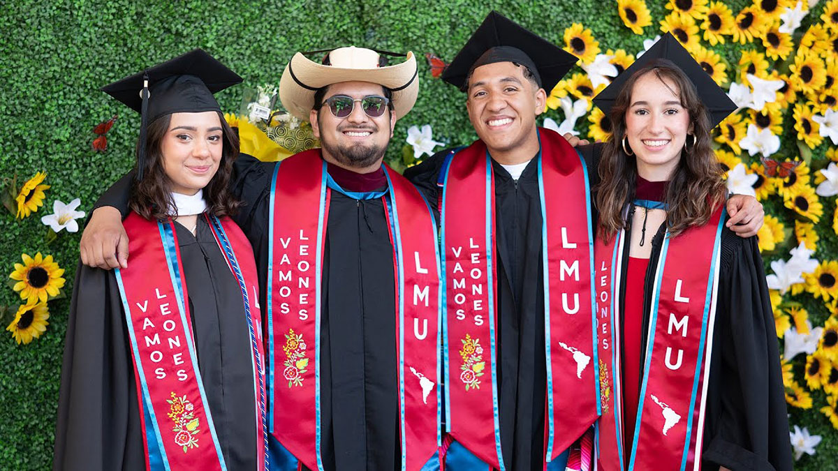 Several graduates smiling on stage together