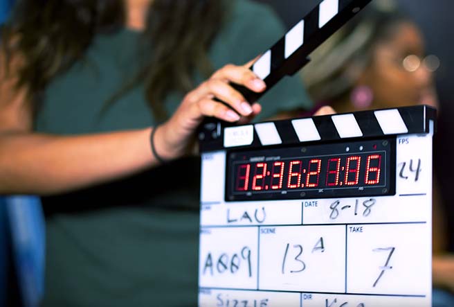 A scene slate being held open by a student