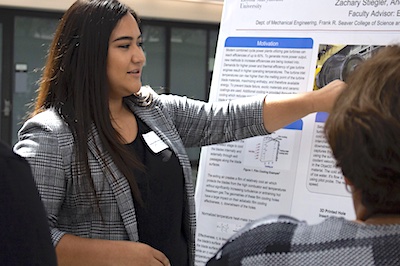 Female McNair scholar giving poster presentation